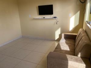 a living room with a couch and a flat screen tv at Mellim Residence in Maragogi