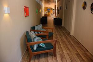 a hallway with two chairs with pillows on them at Pousada Velosmar in Porto De Galinhas