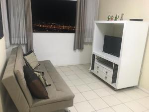 sala de estar con sofá y TV en Residencial Portville Pajuçara, n 1495, en Maceió