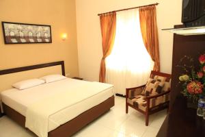 A bed or beds in a room at Arya Graha Semarang