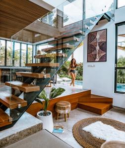 eine Treppe in einem Haus mit einer Frau im Hintergrund in der Unterkunft Beyond Bespoke Villas in Seminyak