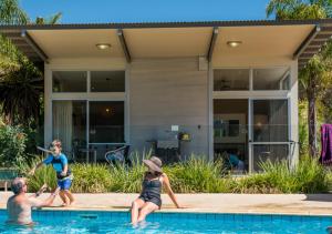 a family playing in the swimming pool of a house at Marion Holiday Park in Adelaide