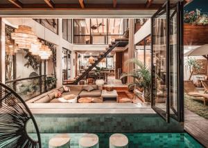 a house with a swimming pool and a living room at Beyond Bespoke Villas in Seminyak