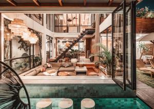 ein Haus mit einem Pool und einem Wohnzimmer in der Unterkunft Beyond Bespoke Villas in Seminyak