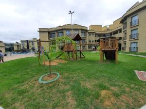 un parque infantil en un parque frente a un edificio en Flat Quartier Aldeia das Águas, en Barra do Piraí