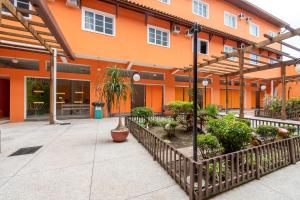 an orange building with a courtyard with plants and a fence at Pousada Estrada do Ouro in Angra dos Reis