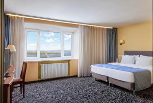 a hotel room with a bed and a window at AZIMUT Hotel Nizhniy Novgorod in Nizhny Novgorod