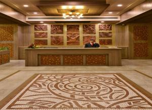 a man standing at a counter in a lobby at Sarovar Portico Gir in Sasan Gir +62 photos