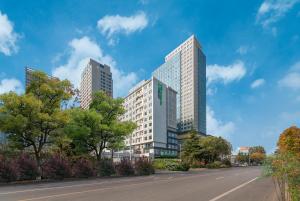 dos edificios altos en una ciudad con una calle en Holiday Inn Express Linyi North New District, an IHG Hotel, en Linyi