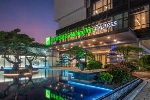 un hotel con piscina di fronte a un edificio di Holiday Inn Express Linyi North New District, an IHG Hotel a Linyi