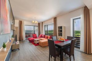 a living room with a red couch and a table at Forest corner in silver mountain of poiana brasov in Poiana Brasov