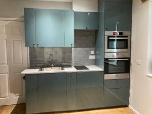 - une cuisine avec des placards bleus et un évier dans l'établissement The Annex, à Carlisle