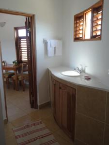 a bathroom with a sink and a mirror at KuDehya Guesthouse in Treasure Beach