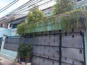a fence with plants on the side of a building at Eiffel Residence Petojo - Female Only in Jakarta