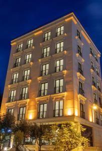 a tall building with lit up windows at night at Mr BEYAZ HOTEL in Istanbul