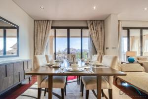 a dining room with a table and chairs and windows at Splendid 2 Bedroom Apartment at Royal Amwaj, Palm Jumeirah by Deluxe Holiday Homes in Dubai