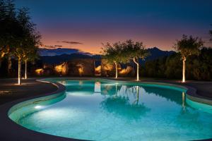 - une piscine avec des arbres en arrière-plan la nuit dans l'établissement Cascioni Eco Retreat, à Arzachena