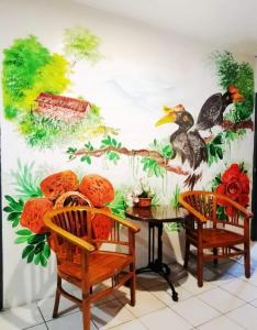 a room with two chairs and a table with birds on the wall at John's Place, Kuching, Sarawak in Kuching