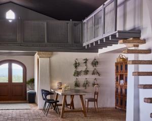une salle à manger avec une table, des chaises et un escalier dans l'établissement Cascioni Eco Retreat, à Arzachena