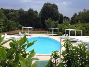 セルヴァ・ディ・ファザーノにある2 bedrooms appartement with shared pool and wifi at Selva di Fasano 9 km away from the beachの大型スイミングプール(ガゼボ2つ付)