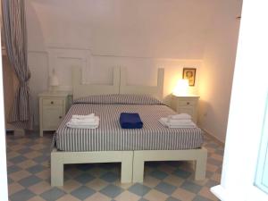 セルヴァ・ディ・ファザーノにある2 bedrooms appartement with shared pool and wifi at Selva di Fasano 9 km away from the beachのベッドルーム1室(青いタオル付きのベッド1台付)