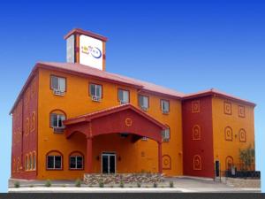 a large orange building with a clock tower at The Soluna Hotel in El Paso