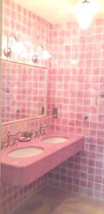 a pink tiled bathroom with two sinks and a mirror at Maison conviviale à Saint-Cybranet avec piscine partagée in Saint-Cybranet
