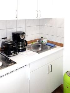 エアフルトにあるCozy apartment in the heart of Erfurt 30 m² city viewのシンクとコンロのある白いキッチン