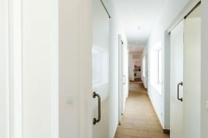 a hallway with white doors and a tile floor at 3 bedrooms villa at Cap d'en Font 800 m away from the beach with sea view private pool and enclosed garden in Cap d'en Font