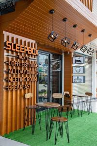 素叻的住宿－Sleepbox Hostel Suratthani，一群桌子和椅子在餐厅外