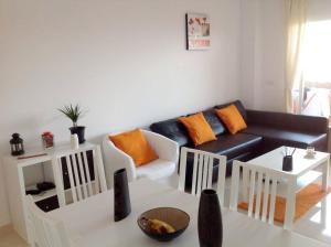 salon z czarną kanapą i pomarańczowymi poduszkami w obiekcie Bright apartment with sea view in Casares, 96 m², pool w mieście Casares