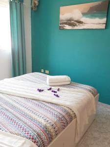 a bed with purple flowers on it in a room at Modern apartment in Candelaria, 130 m² with shared pool in Candelaria