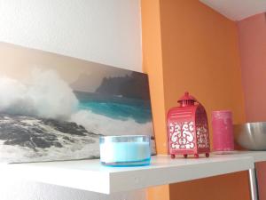 a shelf with a picture of the ocean and a lantern at Modern apartment in Candelaria, 130 m² with shared pool in Candelaria