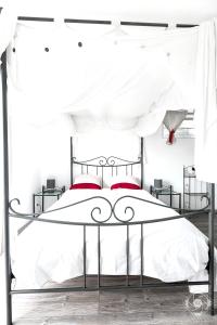 ヴォルップにあるAppartement de 2 chambres avec piscine partagee et jardin clos a Voreppeのベッドルーム(赤い枕の黒と白のベッド付)