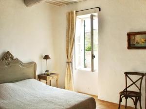 a bedroom with a bed and a window and a chair at Maison de charme à Mollégès avec piscine privée in Mollégès +47 photos