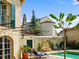 a man sitting in a chair next to a pool at Maison de charme à Mollégès avec piscine privée in Mollégès