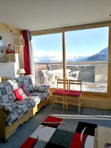 Mâcot La PlagneにあるAppartement d'une chambre a La Plagne Aime 2000 a 10 m des pistes avec vue sur la ville et terrasse amenageeのリビングルーム(ソファ、大きな窓付)