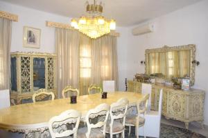 a dining room with a table and chairs and a chandelier at Charming Villa in Monastir with Private Pool in Monastir