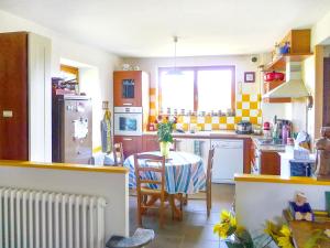 eine Küche mit einem Tisch und einer gelben und weißen Küche in der Unterkunft Maison de 4 chambres avec jardin amenage a Plougrescant a 2 km de la plage in Plouguiel