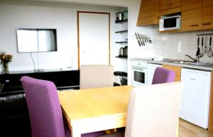 een keuken met een houten tafel en paarse stoelen bij Appartement de 2 chambres a Thollon les Memises a 500 m des pistes avec vue sur le lac et wifi in Thollon
