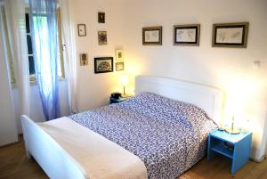 Schlafzimmer mit einem Bett mit einer blauen und weißen Bettdecke in der Unterkunft 3 bedrooms house with sea view enclosed garden and wifi at Lukoran in Lukoran