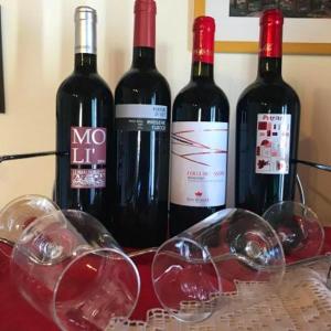 a group of wine bottles and glasses on a table at Charming Apartment in Montenero, Mountain View in Montenero di Bisaccia +22 photos
