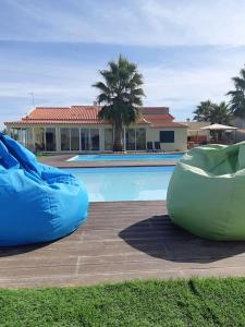 a swimming pool with two bean bags in front of a house at Spacious Villa in Palmela with Private Pool and Garden in Palmela +44 photos