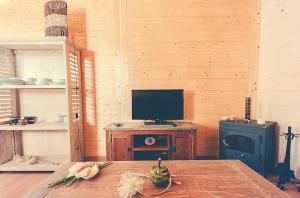 a living room with a television and a table at Charming house in Cañamero with pool and mountain view in Cañamero
