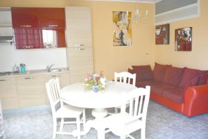 a living room with a white table and a red couch at Charming Apartment Reggio Calabria 60 m² + Parking in Reggio Calabria +11 photos