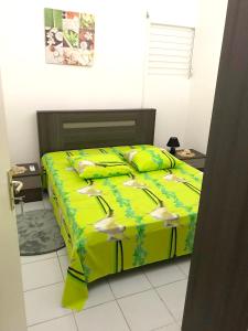 ein Schlafzimmer mit einem Bett mit gelber Decke in der Unterkunft Maison d'une chambre avec jardin clos et wifi a Le Gosier in Le Gosier