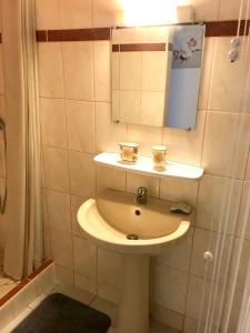 ein Bad mit einem Waschbecken und einem Spiegel in der Unterkunft Maison d'une chambre avec jardin clos et wifi a Le Gosier in Le Gosier