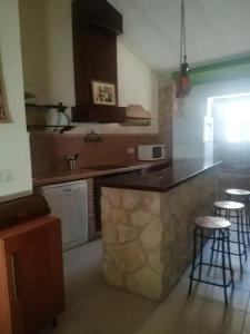 a kitchen with a counter and some bar stools at 2 bedrooms property with shared pool enclosed garden and wifi at Ubeda in Úbeda