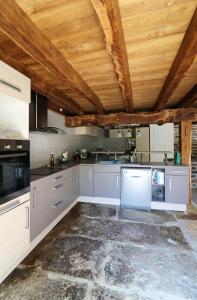 a kitchen with gray cabinets and a wooden ceiling at Maison de 3 chambres avec jardin amenage et wifi a Thegra in Thégra