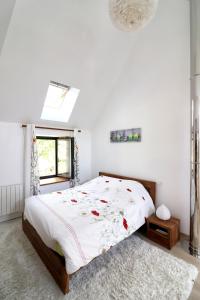 a white bedroom with a large bed with flowers on it at Maison confortable à Thégra avec grand jardin, idéale pour familles. in Thégra